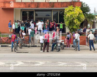 Foule de personnes à l'extérieur d'une succursale bancaire. Certains attendent des services, d'autres font la queue pour obtenir de l'argent de la machine ATM.Santa Clara, Cuba, 2 Banque D'Images