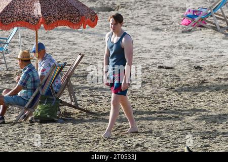 Lyme Regis, Dorset, Royaume-Uni. 4 octobre 2023. Tournage sur la plage à Lyme Regis dans le Dorset pour la 3e série du drame LGBTQ+ de Netflix Heartstopper, sur l’amitié entre adolescents et la jeune romance basée sur le roman graphique d’Alice Oseman, avec Kit Connor dans le rôle de Nick Nelson et Joe Locke dans celui de Charlie Spring. Acteur Kit Connor entre les prises. Crédit photo : Graham Hunt/Alamy Live News Banque D'Images