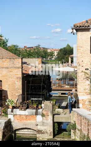 Un jeune couple observe un ancien moulin à eau italien dans la petite ville de Dolo sur les rives de la rivière Brenta Banque D'Images