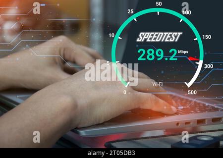 Connexion Internet rapide technologie de bande passante réseau de test de vitesse Homme utilisant l'Internet haut débit avec un smartphone et un ordinateur portable. 5G qualité, vitesse o Banque D'Images