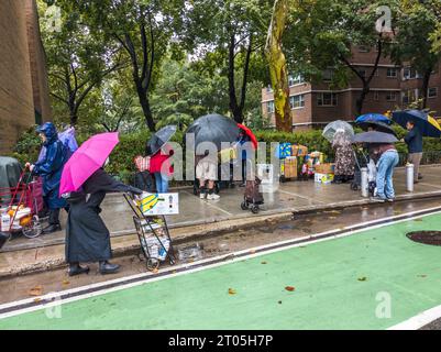 Les clients à l’extérieur de l’église communautaire Manor à Chelsea à New York sous la pluie lors de la distribution de nourriture de leur garde-manger le samedi 23 septembre 2023. (© Richard B. Levine) Banque D'Images