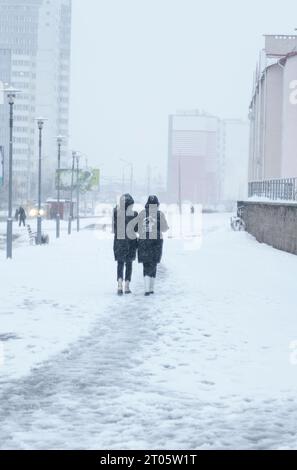 Silhouettes de gens marchant dans la rue dans la neige. Banque D'Images