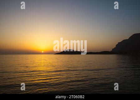 Coucher de soleil sur la mer avec île à l'horizon Banque D'Images