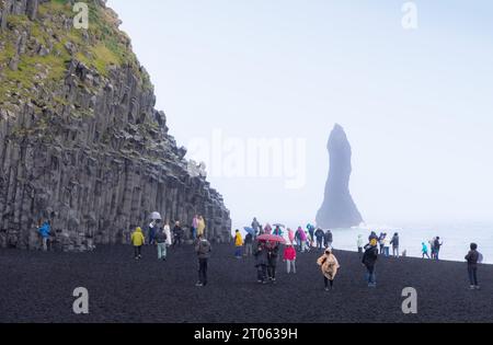 Côte islandaise ; les gens sur la plage de sable noir de Vik, ou la plage de Reynisfjara, côte sud de l'Islande, falaises de basalte et résultats de l'activité volcanique ; Vik, Islande Banque D'Images