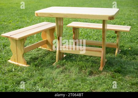 Table en bois se tient sur l'herbe. Meubles dans le parc. Aire de pique-nique vide. Meubles en bois. Banque D'Images