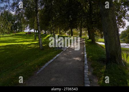 Un chemin pavé incurvé si l'ombre des arbres. Banque D'Images