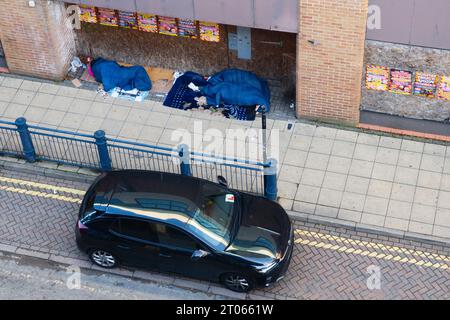 Regardant vers le bas sur deux dormeurs rugueux dans une porte sur New Road, Peterborough Banque D'Images