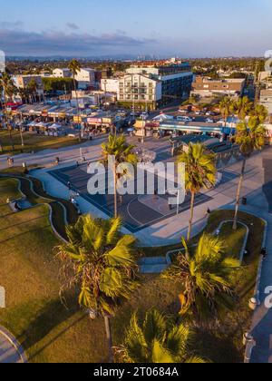 Vues aériennes, prises avec un drone pendant un coucher de soleil hivernal à Venice Beach, Los Angeles, Californie, des terrains de basket-ball, des palmiers, et Curvy lan Banque D'Images