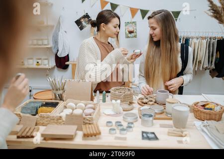 Une fille montre à son amie ce qu'elle aimait parmi les produits d'un magasin écologique Banque D'Images