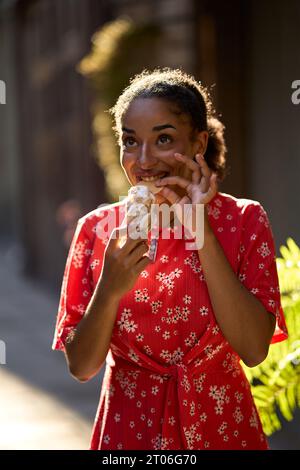Jeune femme latine mangeant une glace dehors Banque D'Images