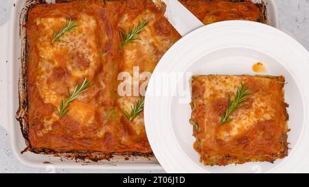 Lasagne aux épinards. Délicieuses lasagnes aux épinards servies avec du romarin frais en gros plan sur une assiette Banque D'Images