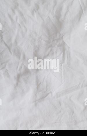 Gros plan d'un drap de literie désordonné. Drap de literie froissé pour fond et décoration. Fond minimal et concept de texture. Pose à plat, vue de dessus. Banque D'Images