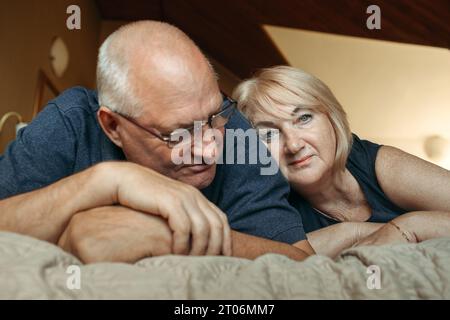 Portrait d'un couple de personnes âgées marié allongé sur le lit. Banque D'Images
