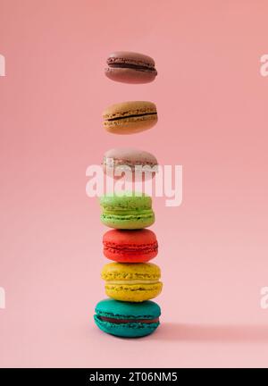 Disposition créative faite de macarons colorés volant sur fond rose pastel. Concept minimal de nourriture sucrée. Idée de cookies macarons tendance. Banque D'Images