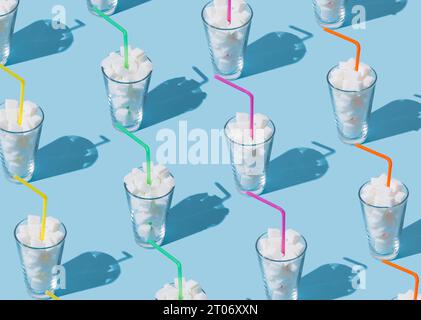 Composition créative de motif faite de verres pleins de cubes de sucre avec des pailles colorées sur fond bleu clair lumineux. Régime alimentaire malsain minimal Banque D'Images