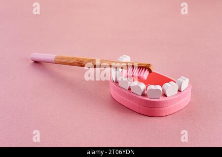 Journée nationale des broussailles. Dent avec brosse à dents sur fond rose. Concept de santé dentaire. Banque D'Images