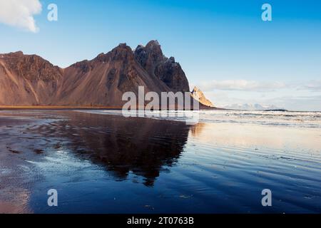 Hautes collines alpines de vestrahorn, environnement fantastique islandais sur la péninsule de Stokksnes. Vue d'ensemble des paysages scandinaves nordiques avec une belle plage de sable noir en Islande gelée. Banque D'Images