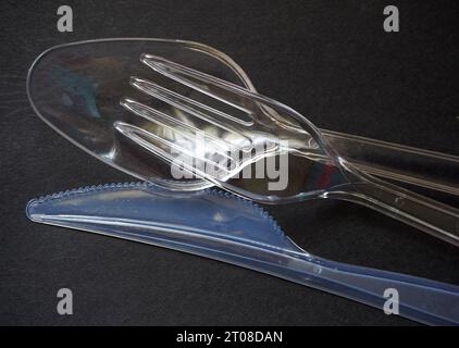 Fourchette en plastique à usage unique, cuillère et couteau sur un noir. Couverts en matières plastiques Banque D'Images