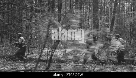 Soldats américains de l'infanterie américaine de la Seconde Guerre mondiale marchant Running Run le long de la forêt en automne jour de printemps. Groupe de soldats Banque D'Images