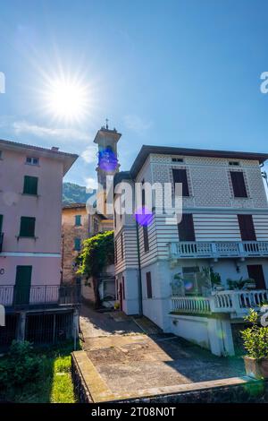 Ville de Porto Ceresio et Tour de l'église dans une journée d'été ensoleillée avec Sunbeam à Porto Ceresio, Lombardie, Italie Banque D'Images