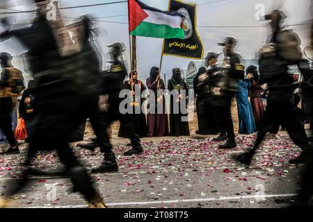 Gaza City, Palestine. 04 octobre 2023. Les partisans des Brigades Al Qods, la branche armée du mouvement du Jihad islamique palestinien (JIP), les aspergent de pétales de fleurs alors qu'ils célèbrent le 36e anniversaire de la fondation du mouvement par un défilé dans le sud de la bande de Gaza. Crédit : SOPA Images Limited/Alamy Live News Banque D'Images