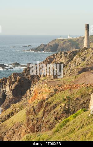 Vue sur le phare de Pendeen avec des tas de déchets miniers d'étain au premier plan - John Gollop Banque D'Images