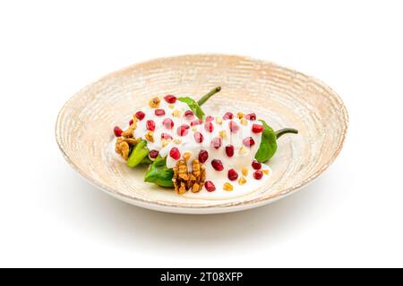 Chiles en Nogada, un plat mexicain traditionnel à base de piment pablano farci de viande et de fruits et garni de graines de grenade et de noix Banque D'Images