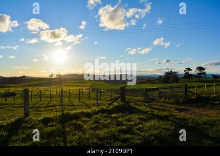 Coucher de soleil Nouvelle-Zélande. Soleil brillant derrière les montagnes à l'horizon. Banque D'Images