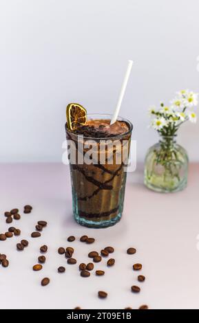 Boisson de cacao avec banane et beurre d'arachide sur une table avec vase de fleurs Banque D'Images