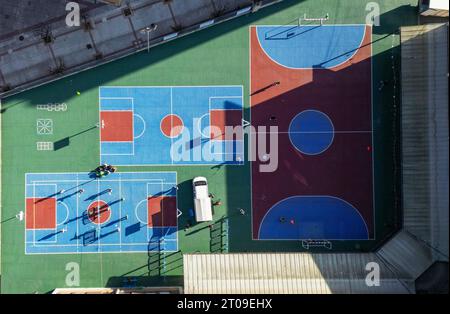 Vue drone de la piste garée près de terrains de football colorés de différentes tailles avec des lignes en plein jour Banque D'Images