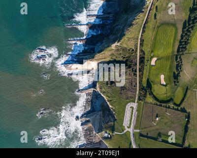 Drone à couper le souffle de la côte basque verdoyante avec falaise rocheuse contre mer verte ondulante avec mousse au soleil Banque D'Images