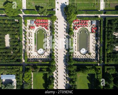 Vue de dessus drone du sentier et des haies vertes dans le jardin du château de Versailles avec fontaines sous la lumière du soleil Banque D'Images