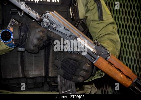 Soldat lourdement équipé en uniforme de camouflage, membre de forces spéciales pour les opérations antiterroristes et les combats rapprochés en guerre, tenant une arme à feu Banque D'Images