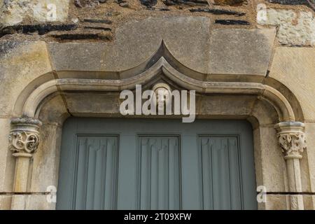 Angers, France, 2023. Une tête sculptée médiévale (mascaron) sur le linteau de pierre de la porte menant à l'intérieur d'une des tourelles du Châtelet Banque D'Images