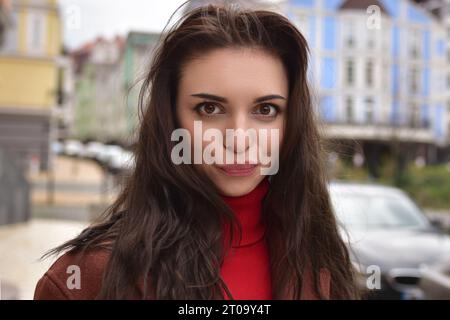 Portrait d'une jeune femme mignonne dans un manteau d'automne brun dans la rue avec une émotion drôle de caprice. Banque D'Images