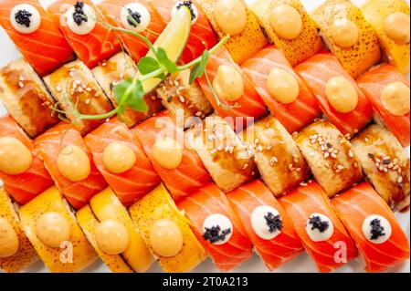 Assortiment de sushi grand ensemble gros plan arrière-plan. Une variété de sushis japonais avec thon, crabe, saumon, anguille et rouleaux. Vue de dessus. Photo de haute qualité Banque D'Images