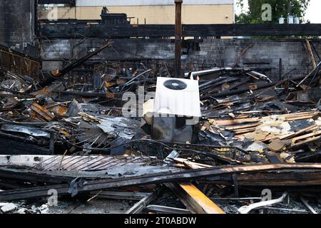 Bâtiment brûlé au sol. Destruction complète du bâtiment après le début du feu dans le sous-sol. Structure effondrée carbonisée avec poutres en bois, courbée Banque D'Images