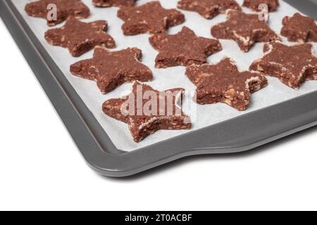 Biscuit au chocolat sans gluten sur papier parchemin et plaque à pâtisserie. Biscuit au chocolat à la farine d'amande avec rebord cannelle de sucre, forme d'étoile. Recette suisse 'Bas Banque D'Images