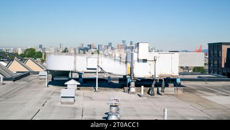 Unité de CVC sur toit plat avec horizon du centre-ville, évents et trappes de toit et ciel bleu. Unité d'air d'appoint sur toit ou unité de toit emballée sur un residenti Banque D'Images