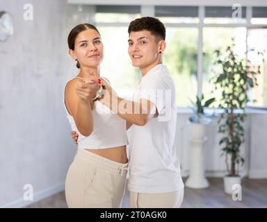 Les filles et les gars dansent la chorégraphie synchrone de groupe dans la salle de danse Banque D'Images