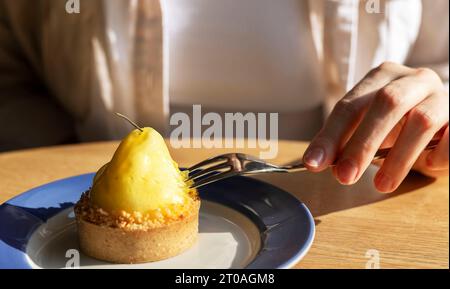 Dessert mangeant à la main dans un café. Pâte à mousse, confiserie en tartelette Banque D'Images