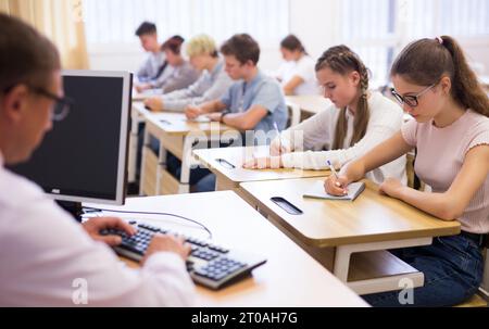 Les adolescents qui travaillent en classe pendant la leçon Banque D'Images