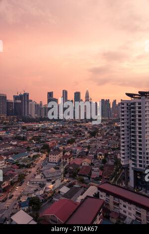 Vue sur Kampung Datuk Keramat au coucher du soleil avec les gratte-ciel du centre-ville de Kuala Lumpur et les tours Petronas en arrière-plan Banque D'Images