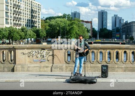 Berlin, Allemagne, juillet 20 : le guitariste musicien de rue interprète ses chansons sur un pont à Berlin le 20 juillet 2023. Banque D'Images