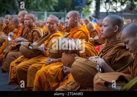 CHIANG MAI, THAÏLANDE - décembre 26 2015 : jeune moine dormant pendant la cérémonie traditionnelle d'aumônes bouddhistes au petit matin. Annuel 10 000 buddh Banque D'Images