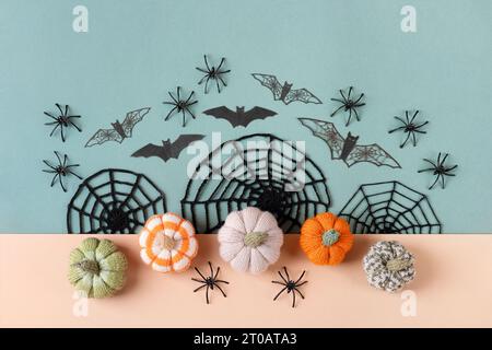 Décorations d'Halloween, araignées, chauves-souris, toiles tricotées, citrouilles sur fond vert et beige. Joyeux concept de vacances Halloween. Pose à plat, vue de dessus Banque D'Images