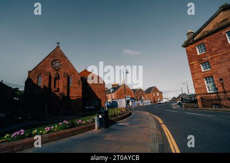 Dunbar, East Lothian , écosse - 13 août 2023 vue générale de Sunlit High Street avec des bâtiments peints et des pots de fleurs en fleurs en premier plan. Bonjour Banque D'Images