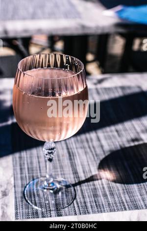Verre à vin rempli de vin rosé mousseux. Banque D'Images