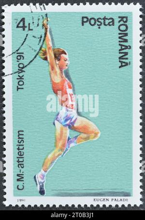 Timbre-poste annulé imprimé par la Roumanie, qui montre le saut en longueur, Championnats du monde d'athlétisme, Tokyo, vers 1991. Banque D'Images