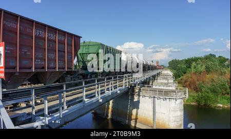 Région de Kaliningrad, Russie, 26 juin 2023. Un train de marchandises passe sur le pont. Wagons du train de marchandises sur le pont. Banque D'Images